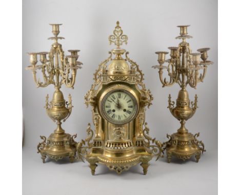French brass garniture, comprising clock, circular dial, cylinder movement striking on a bell, cloth covered plinth, and a pa