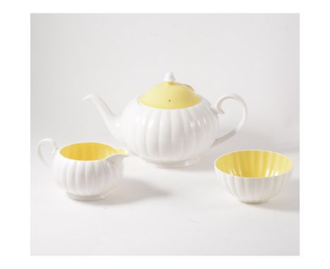 A Susie Cooper three piece teaset, white flute design with yellow interior and cover to teapot. Marked Susie Cooper Bone Chin