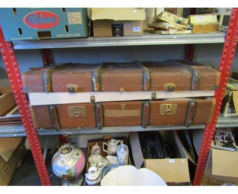 A large travel trunk containing mostly children's dolls and games