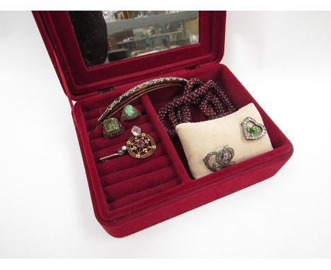 A jewellery box with contents including a gold ring with clear quartz cabochon stamped 9ct, garnet bead necklace, enamelled r