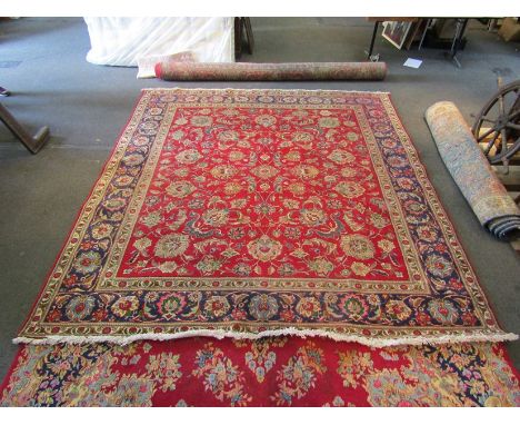 A Persian red and blue ground Tabriz carpet with central floral panel, multiple borders, 340cm x 306cm