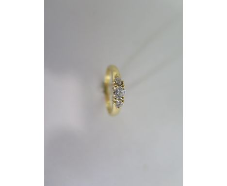 An 18ct yellow gold three stone diamond ring - size K/L - approx 2.8 grams, central diamond approx 0.20ct - diamonds bright c