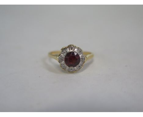 An 18ct gold ring with large ruby style central stone surrounded with white stones, size L, approximately 3g 