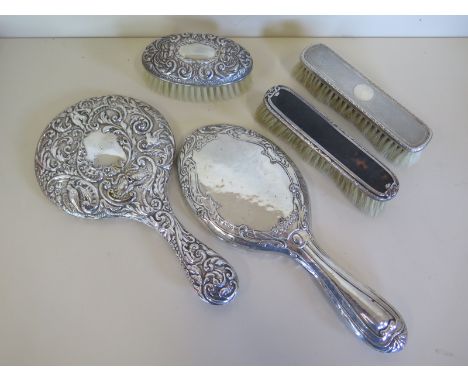 A silver and tortoise shell backed brush together with two other silver backed brushes and two silver mirrors, all in with si