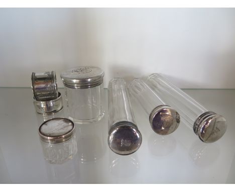 Five silver top bottles and two serviette rings 