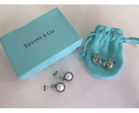 A pair of Tiffany and Co Peretti silver earrings and a pair of silver and pearl earrings, some usage but with Tiffany pouch a