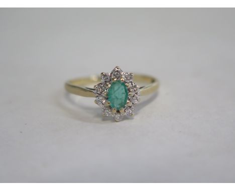 A 9ct gold ring with emerald style stone surrounded by small white stones, size S, approximately 2.2g 