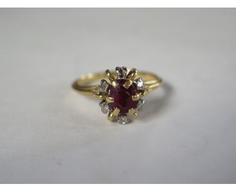 An 18ct gold ring with ruby encircled by five diamonds, one stone missing, size O/P, approximately 5.1g 