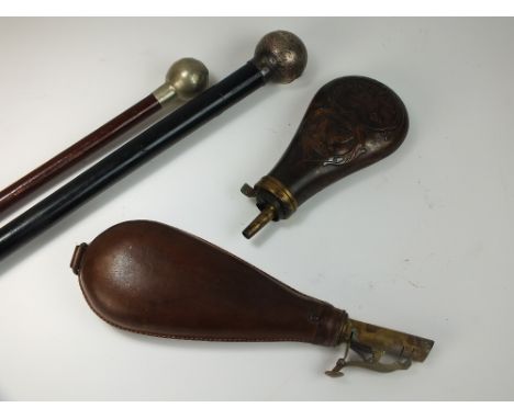 Two 19th century powder flasks, the first engraved with a hunting dog and two birds, the second with brown leather exterior, 