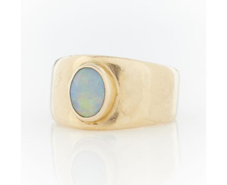 14k yellow gold bezel ring set with oval opal cabochon. Marked 14k with marker's mark along the interior.Ring size: US 8.25. 