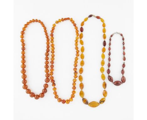 Group of necklaces including:One amber necklace of spherical beads, graduating in size towards the center (smallest 10.85 mm,