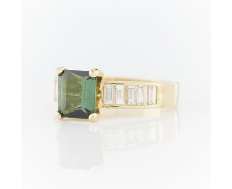 18k yellow gold ring set with central step cut chrome tourmaline with five baguette cut diamonds channel set on either side. 
