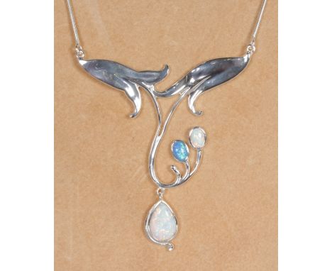 AN ART NOUVEAU SILVER AND TWO-COLOUR OPAL PENDANT on a chain.