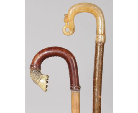 A HORSES HOOF HANDLED STICK and a VERY LONG CARVED HORN HANDLED STICK (2).