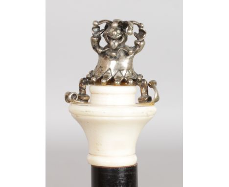 A SILVER AND IVORY TOPPED "JESTER" CANE. Date: 1930.  Country: European. A very unusual silver jester with mouth open and ton