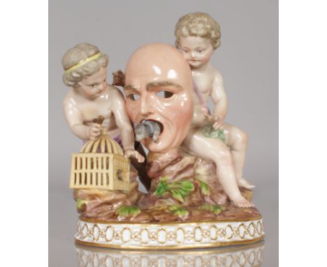 A RARE 19TH CENTURY MEISSEN GROUP OF TWO SEATED CUPIDS holding a mask, a cat coming out of its mouth, an empty basket on the 