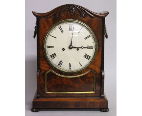 A LATE REGENCY MAHOGANY BRACKET CLOCK with serpentine top, brass grilled sides and carrying handles on bun feet, the white di