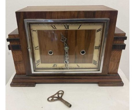 An Art Deco walnut mantel clock, with Roman numerals to the chapter ring and with stepped rectangular case, width 35cm.