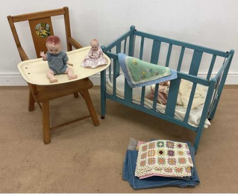 A child's lowchair and a doll's cot, together with associated items including two small dolls and clothing and bedding.