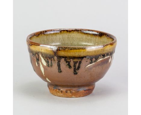 JIM MALONE (born 1946); a stoneware chawan covered in kaki and green ash glaze with wax resist and running tenmoku glaze deco