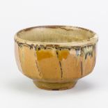 MIKE DODD (born 1943); a stoneware faceted bowl covered in river iron over Shap granite glaze,