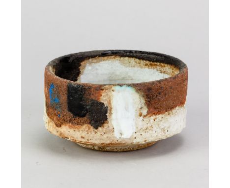 ROBIN WELCH (1936-2019); a stoneware bowl covered in grey and rusty glaze decorated with black, white and blue enamel, impres