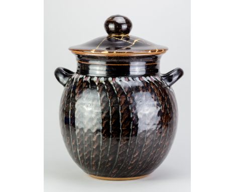 DAVID LLOYD JONES (1928-1994); a large stoneware twin handled jar and cover covered in tenmoku breaking to kaki glaze with co