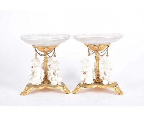 A pair of gilt metal and moulded glass bonbon dishes, the part frosted dished glass with Greek key decoration, upon gilt pede