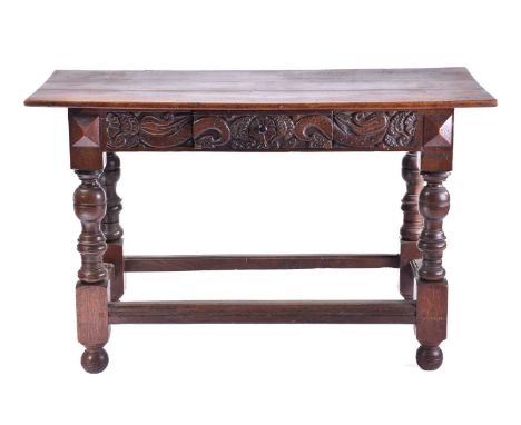 A 17th-century style oak single drawer side table with a planked top and carved frieze, on turned cup and cover supports unit