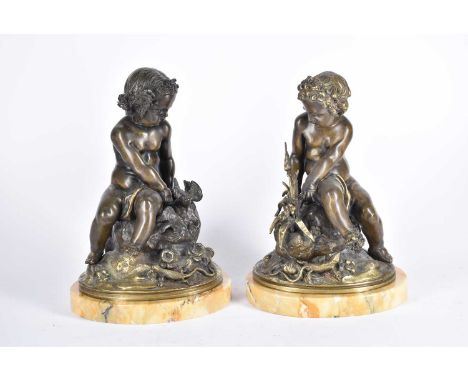 A pair of 19th century Italian bronze cherubs, each seated on a rock, one with birds, the other with flowers, with a lizrd at
