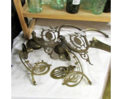 A pair of gas wall light brackets and a pair of brass piano candle sconces.