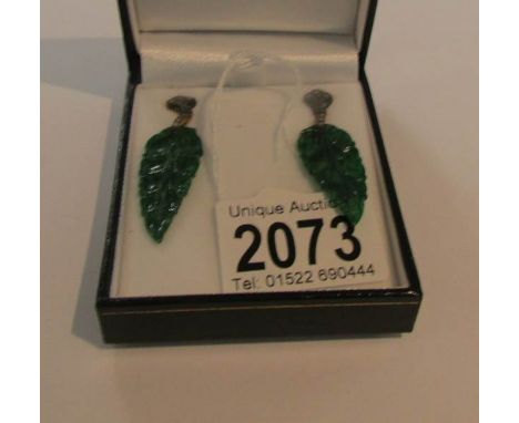 A pair of drop earring set with jade in the form of leaves set emeralds and diamonds.