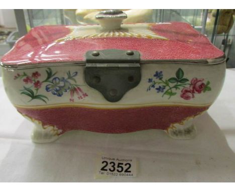 A ceramic biscuit box with metal fittings.