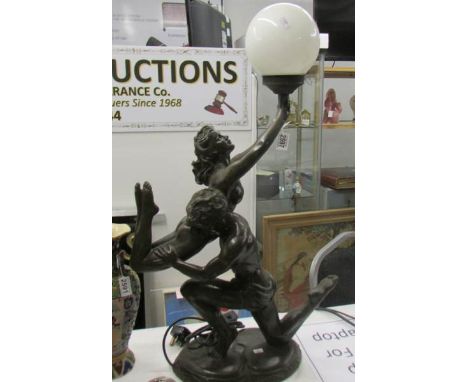 A modern figural table lamp with white glass globe shade.