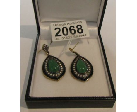 A pair of gold and silver drop earrings set with jade, onyx and diamonds.