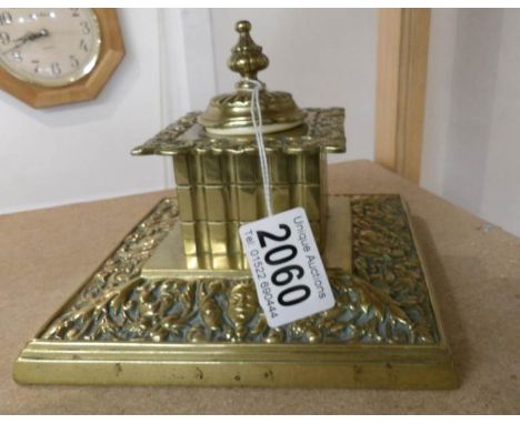 A brass inkwell with replacement liner.
