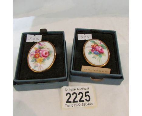 A pair of Royal Worcester brooches with safety chains.