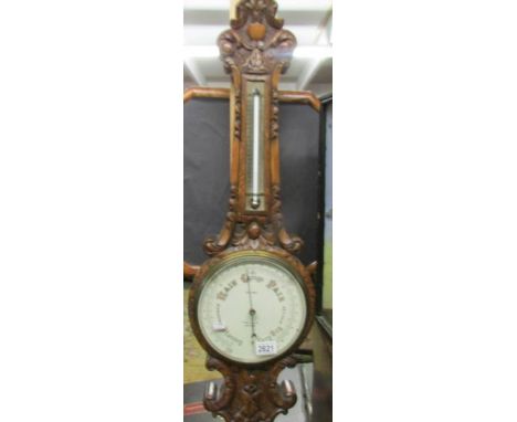A carved oak barometer/thermometer marked Rae Bros., 77, Renfield St., Glasgow.