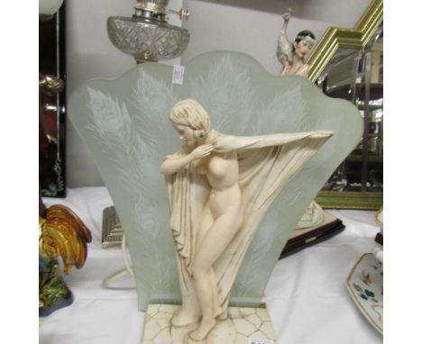 A nude figure table lamp with fan shaped glass shade.