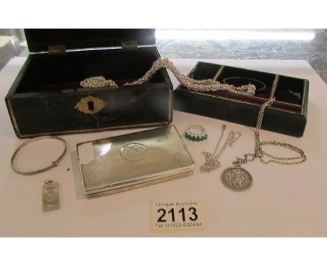 A collection of silver and white metal items in a vintage jewellery box including silver ingot, silver St. Anthony pendant, n