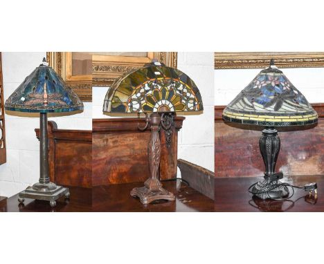 An Art Nouveau Style Bronzed Lamp Base, with Tiffany style leaded glass shade of arch form, 68cm high, together with two furt