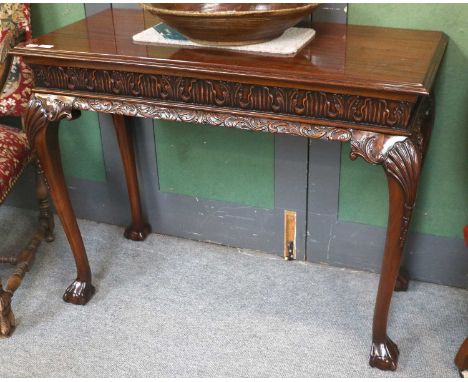 A Reproduction Carved Mahogany Console Table, in George III style, with acanthus frieze and shell mounted supports terminatin