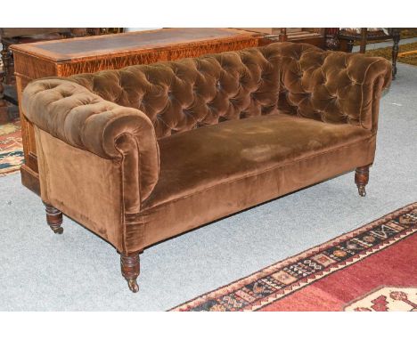 A Victorian Chesterfield Two Seat Sofa, upholstered in brown velvet and on turned mahogany supports with brass castors, 166cm
