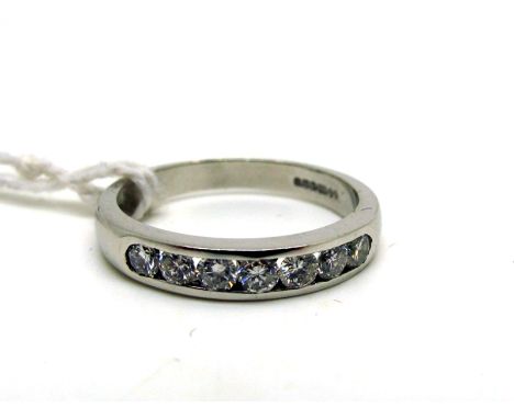 A Modern 18ct White Gold Seven Stone Diamond Ring, channel rubover set with uniform brilliant cut stones (finger size N). 