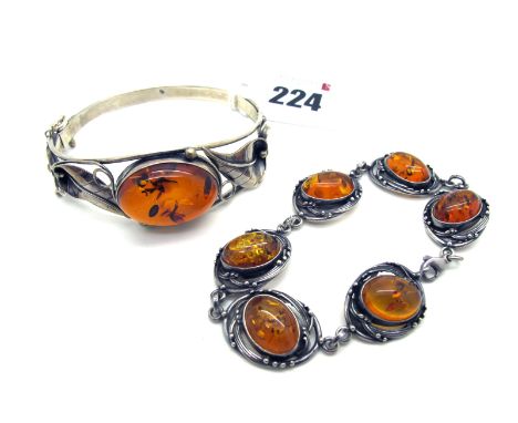 A Modern Openwork Bangle, oval collet set to the centre, between stylised lily detail, hinged to snap clasp, stamped "925"; t