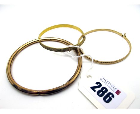 A Dainty Bangle, stamped "9KT"; together with an engine turned expanding bangle and a Rolled Gold bangle (3)