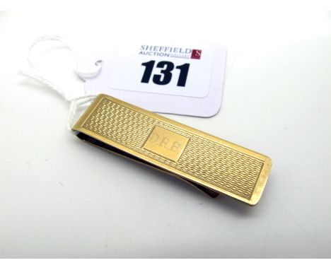 A 9ct Gold Money Clip, engine turned decoration and engraved initials "DRB", overall length 5cm (10grams). 
