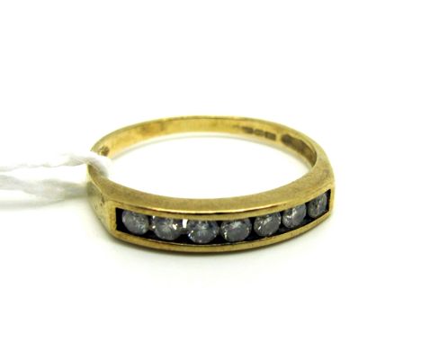 A Modern 9ct Gold Seven Stone Diamond Set Ring, channel set with uniform stones (finger size P1/2) (1.7grams). [802555] 