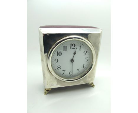 A Hallmarked Silver Mounted Mantel Clock, (marks rubbed) the white dial with black Arabic numerals, raised on four feet, 15cm