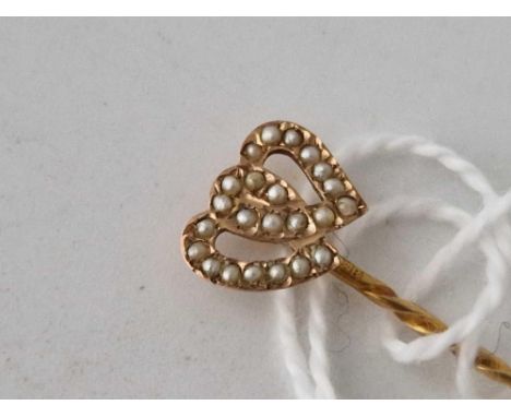 A gold topped pearl double heart stick pin